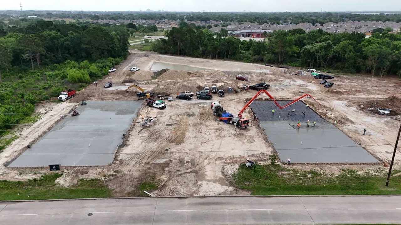 Bammel North day 80: aerial view, both Phase 1 pads cast with concrete pump truck mid-second-pour, 18 May 2026